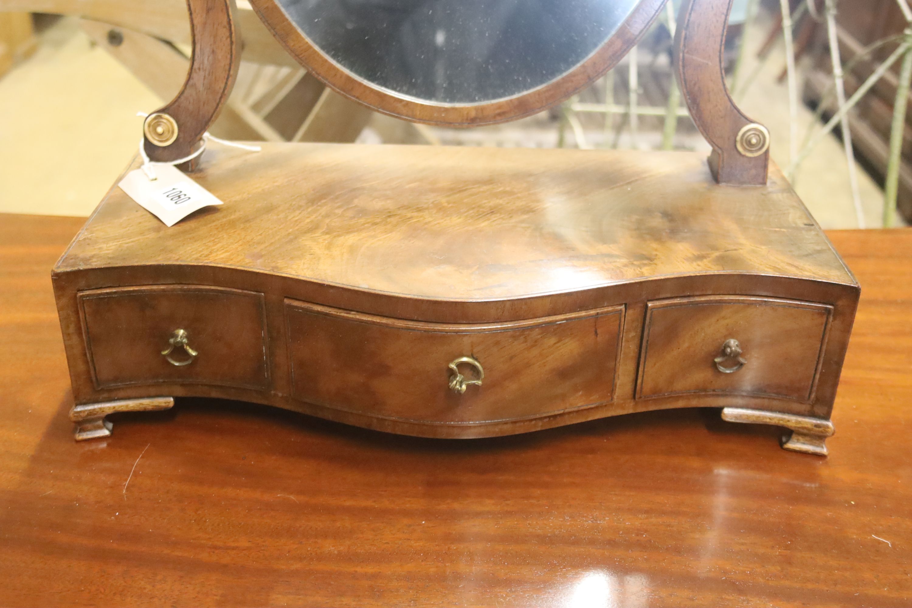 A George III mahogany serpentine toilet mirror, width 42cm, depth 22cm, height 57cm